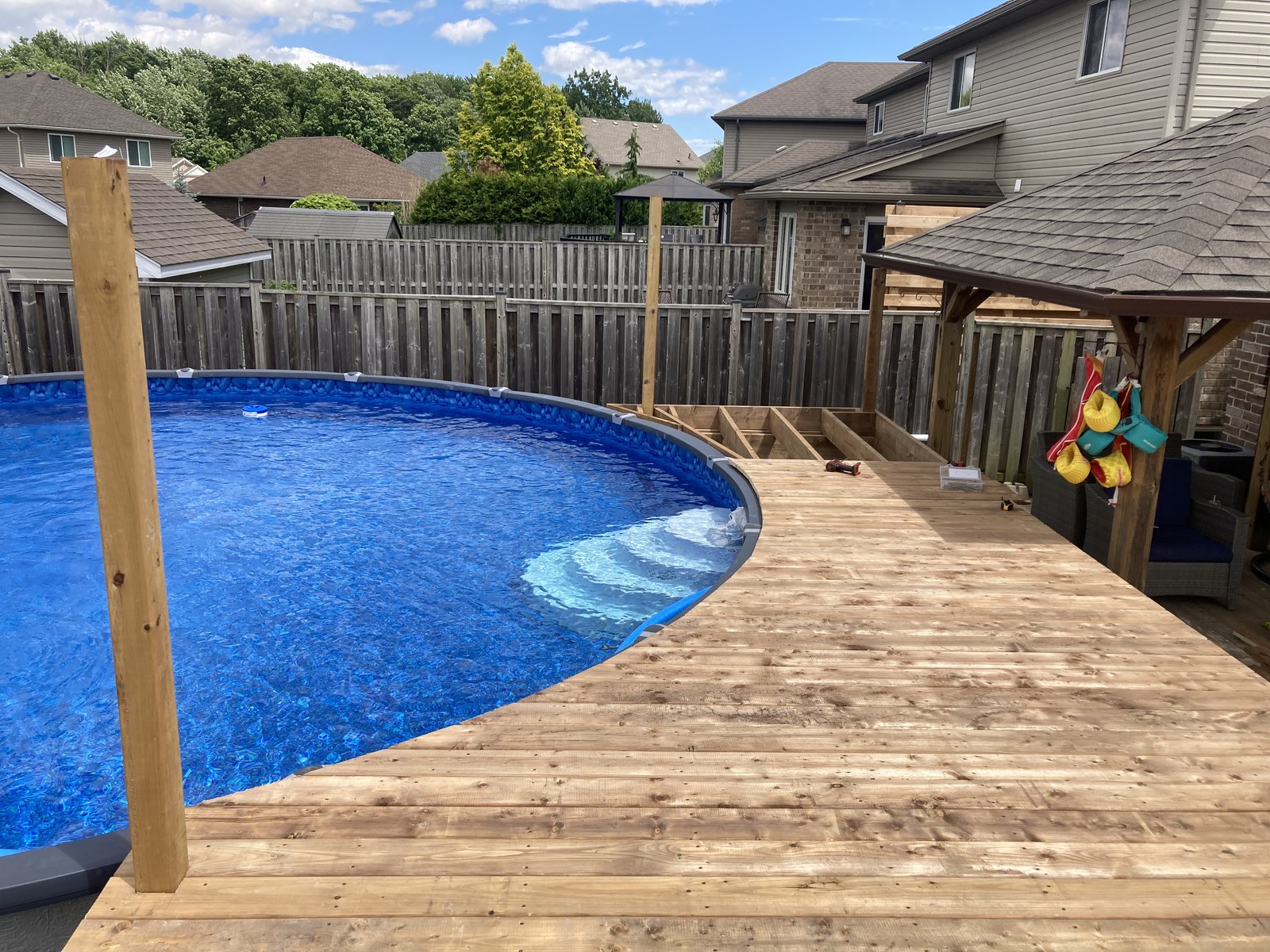 Backyard pool deck and outdoor living area by Cutting Edge Carpentry