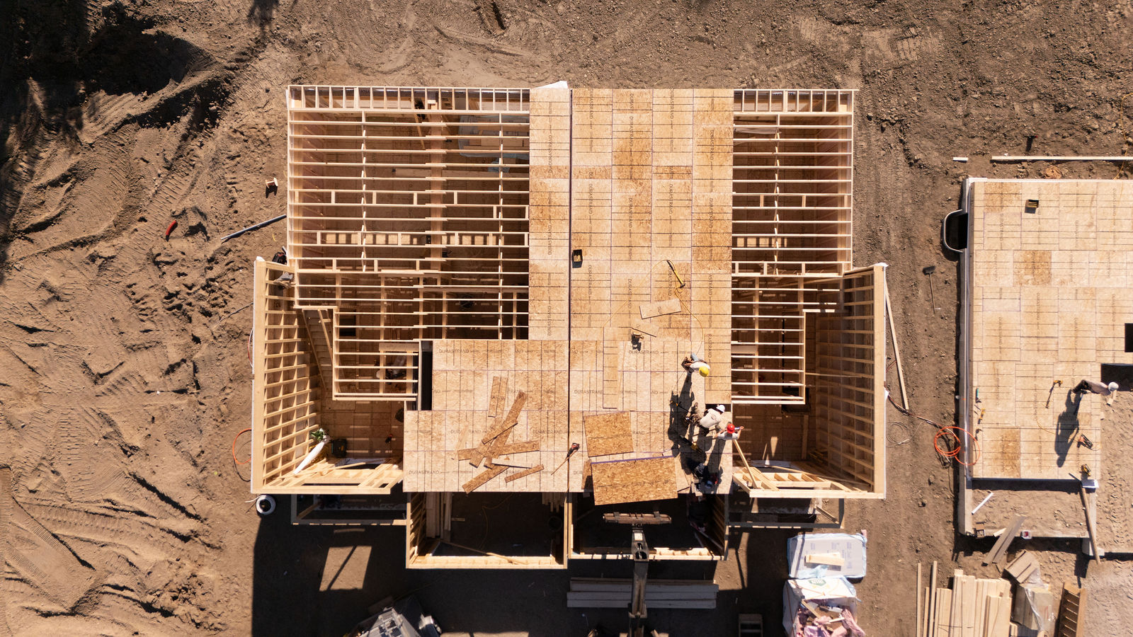 Top-down drone view of residential framing work