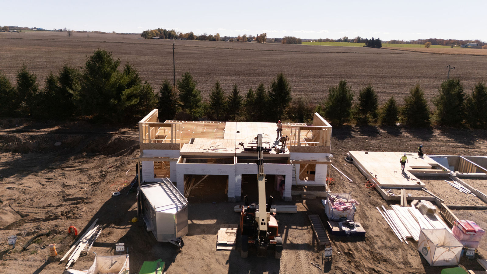 Wide drone view of custom home construction progress