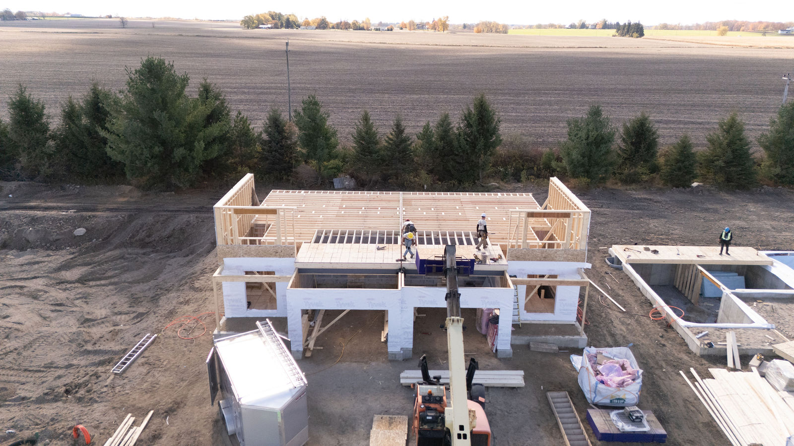 Custom home framing with lift equipment and jobsite materials