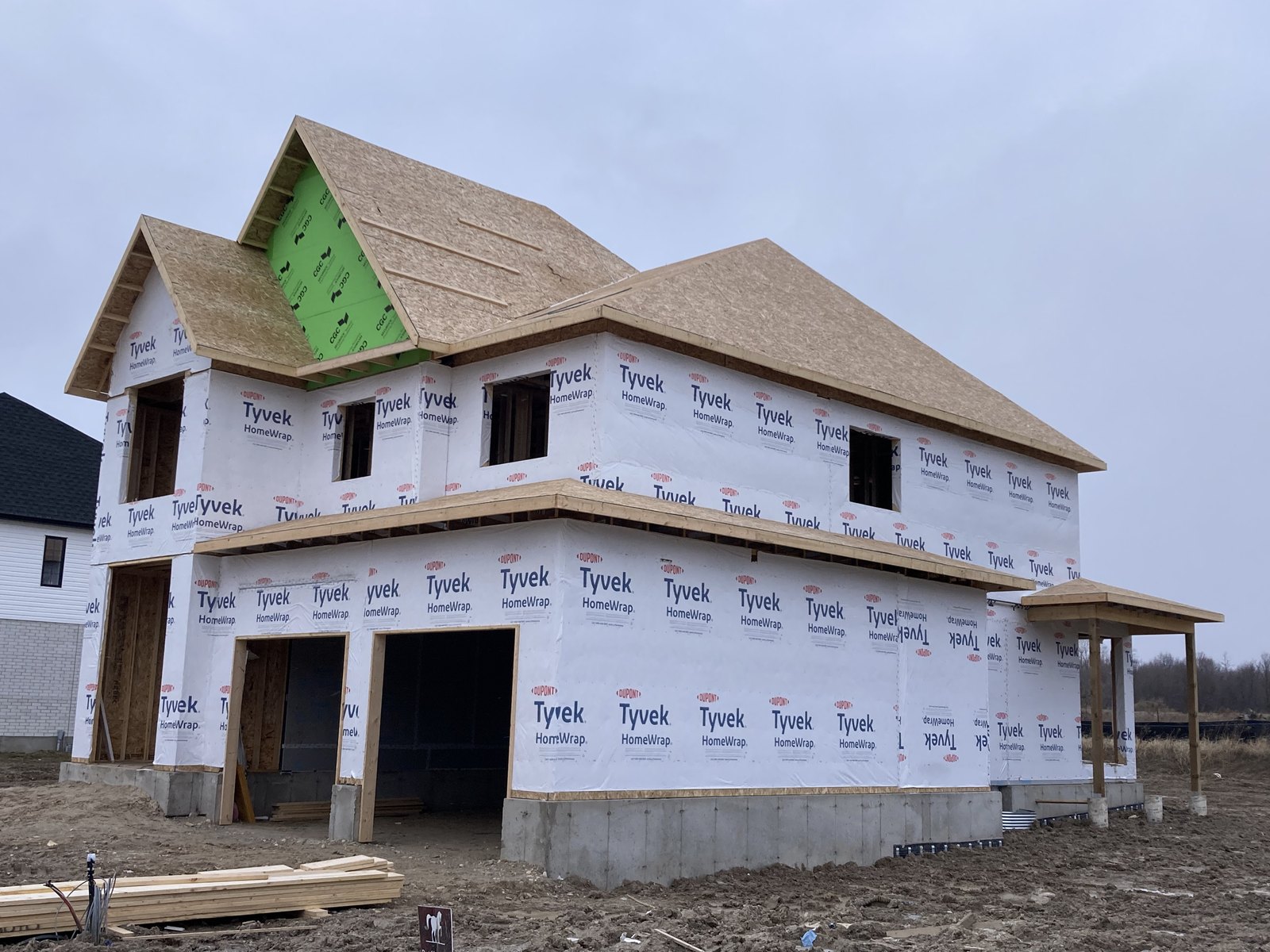 Two-storey custom home framing with house wrap installed