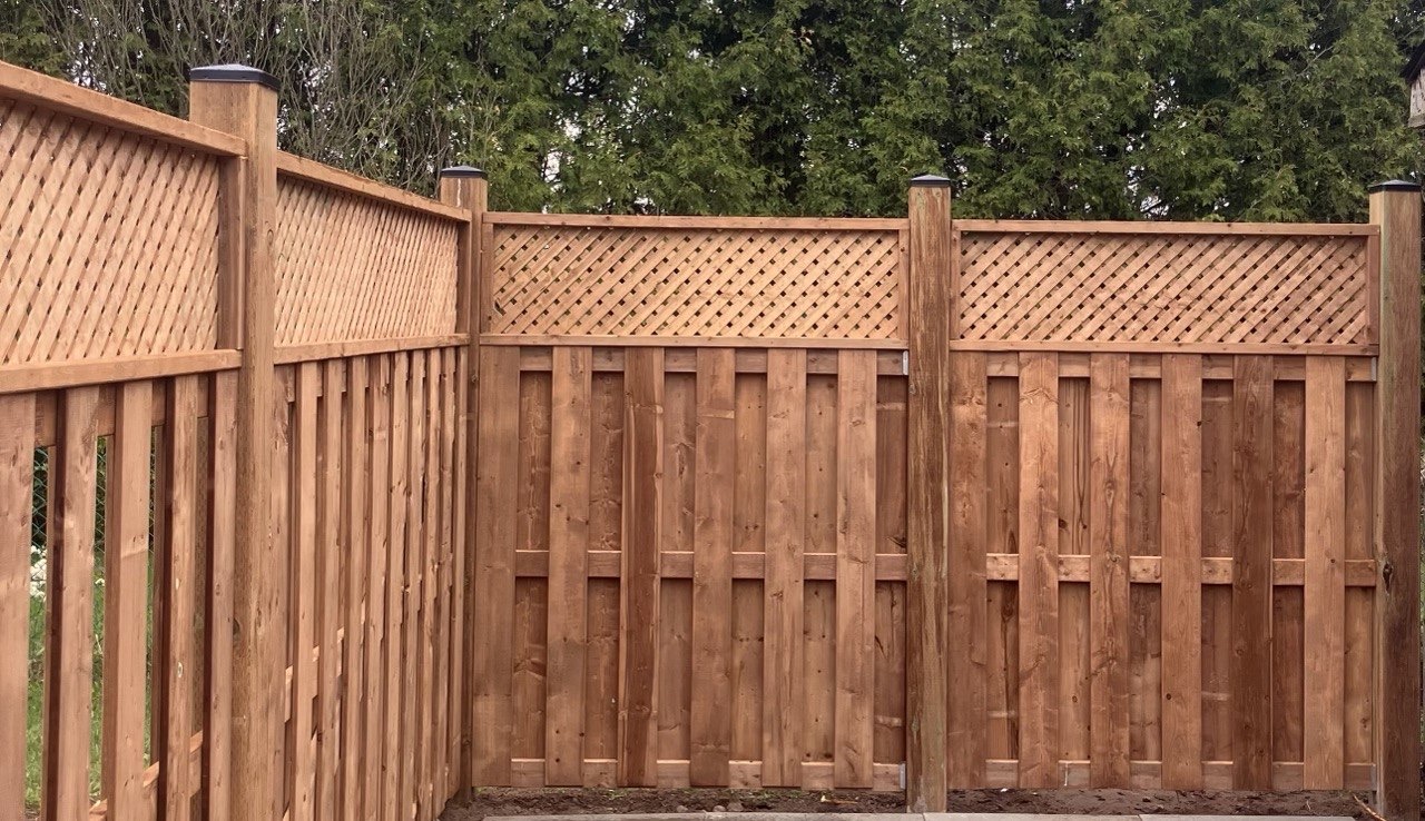 Wood privacy fence with lattice detail by Cutting Edge Carpentry